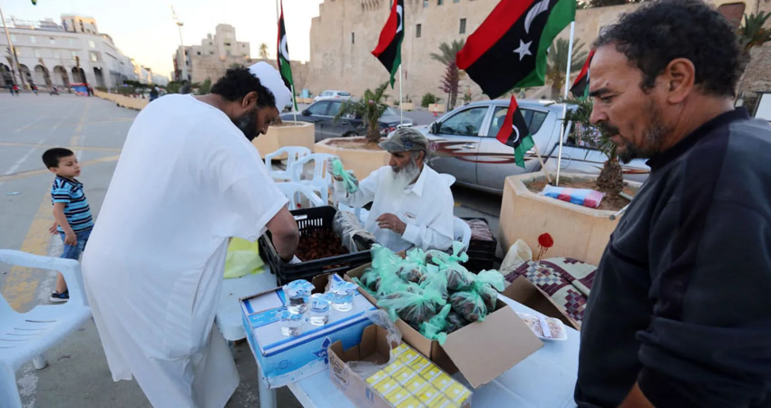 ليبيون يوزعون طعام الافطار في ساحة الشهداء بالعاصمة الليبية (أ.ف.ب)