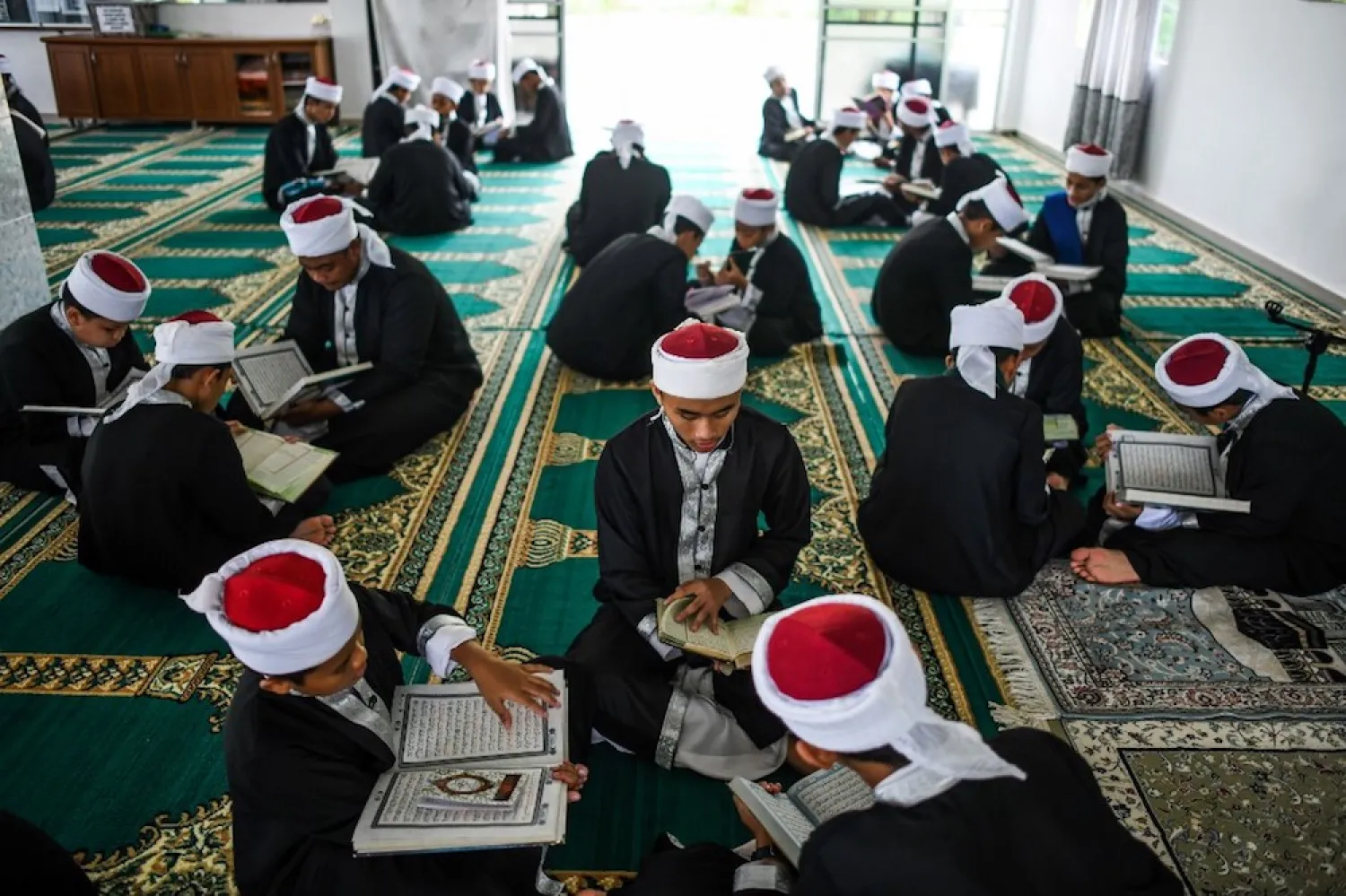 Muslim students read copies of the holy Quran to observe Nuzul al-Quran in a mosque in Bentong May 23, 2019. (AFP)