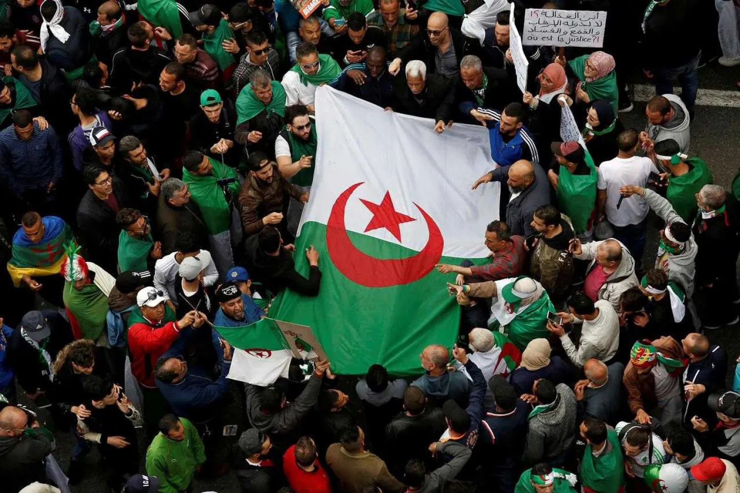 FILE PHOTO: Demonstrators hold flags and banners as they return to the streets to press demands for wholesale democratic change well beyond former president Abdelaziz Bouteflika's resignation in Algiers, Algeria April 19, 2019. REUTERS