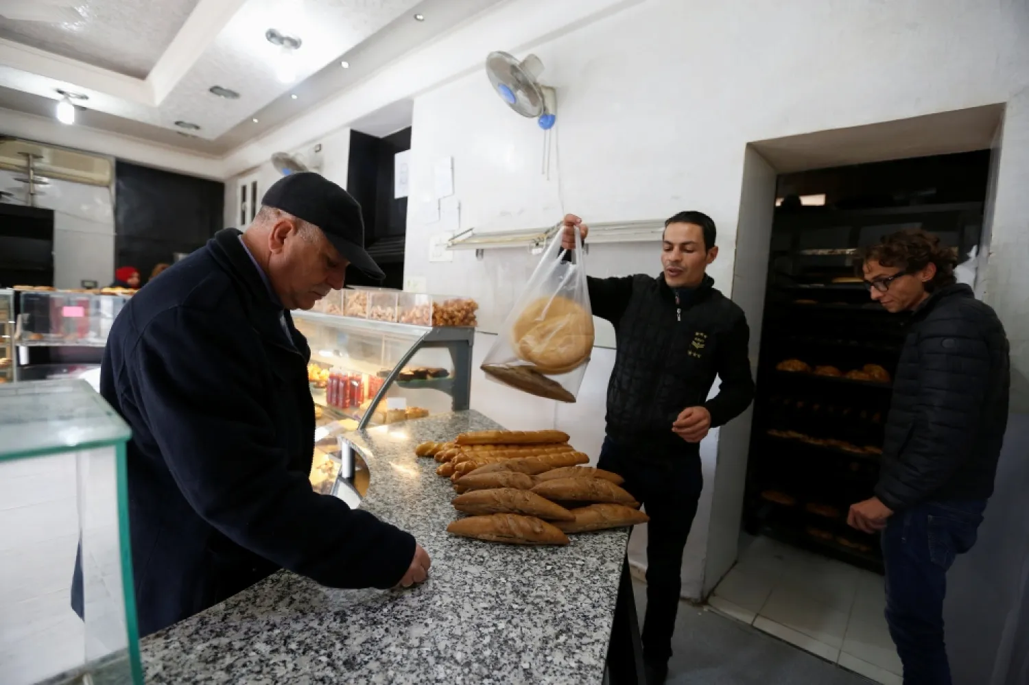 A customer buys bread at the shop of a bakery in Tunis, Tunisia. (Reuters)