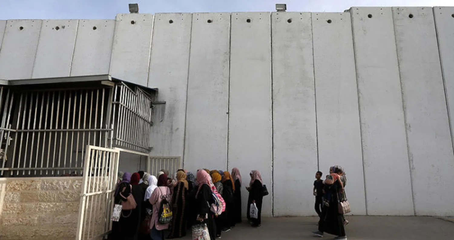 فلسطينيات يجتزن حاجزاً أمنياً في طريقهن إلى المسجد الأقصى في القدس الجمعة الماضي (إ.ب.أ)