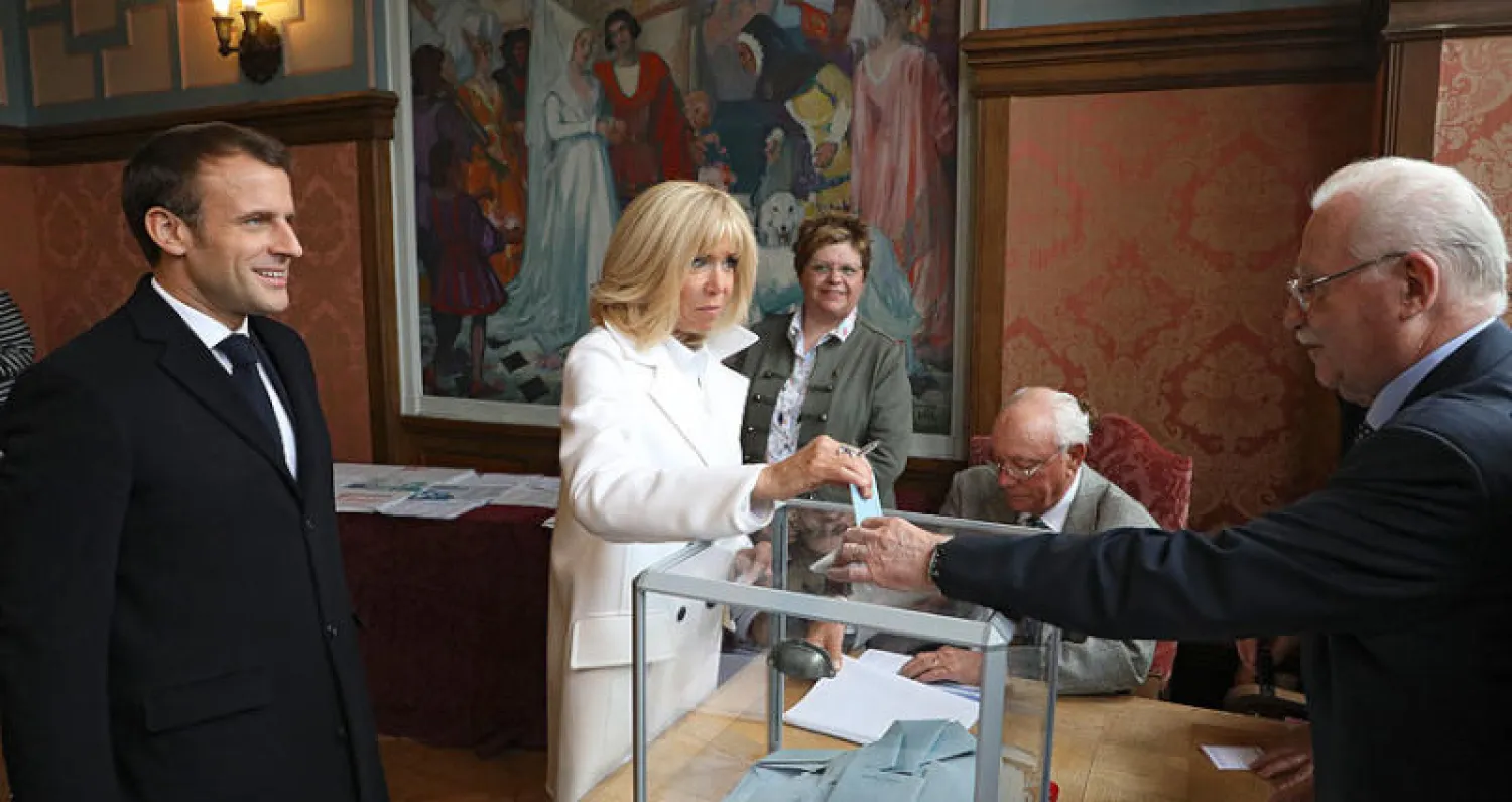 ماكرون وزوجته يدليان بصوتيهما في لوتوكيه شمالي فرنسا أمس (أ.ب)