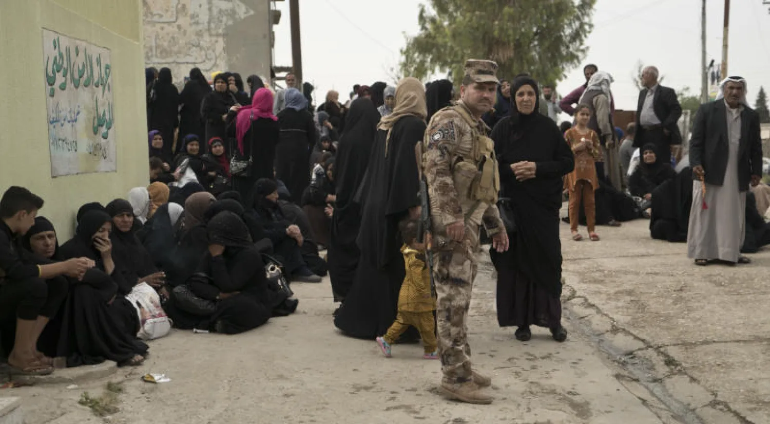 أقارب ينتظرون خارج محكمة نينوى الجنائية حيث جرت محاكمة متهمين بالانتماء إلى «داعش» العام الماضي (أ.ب)