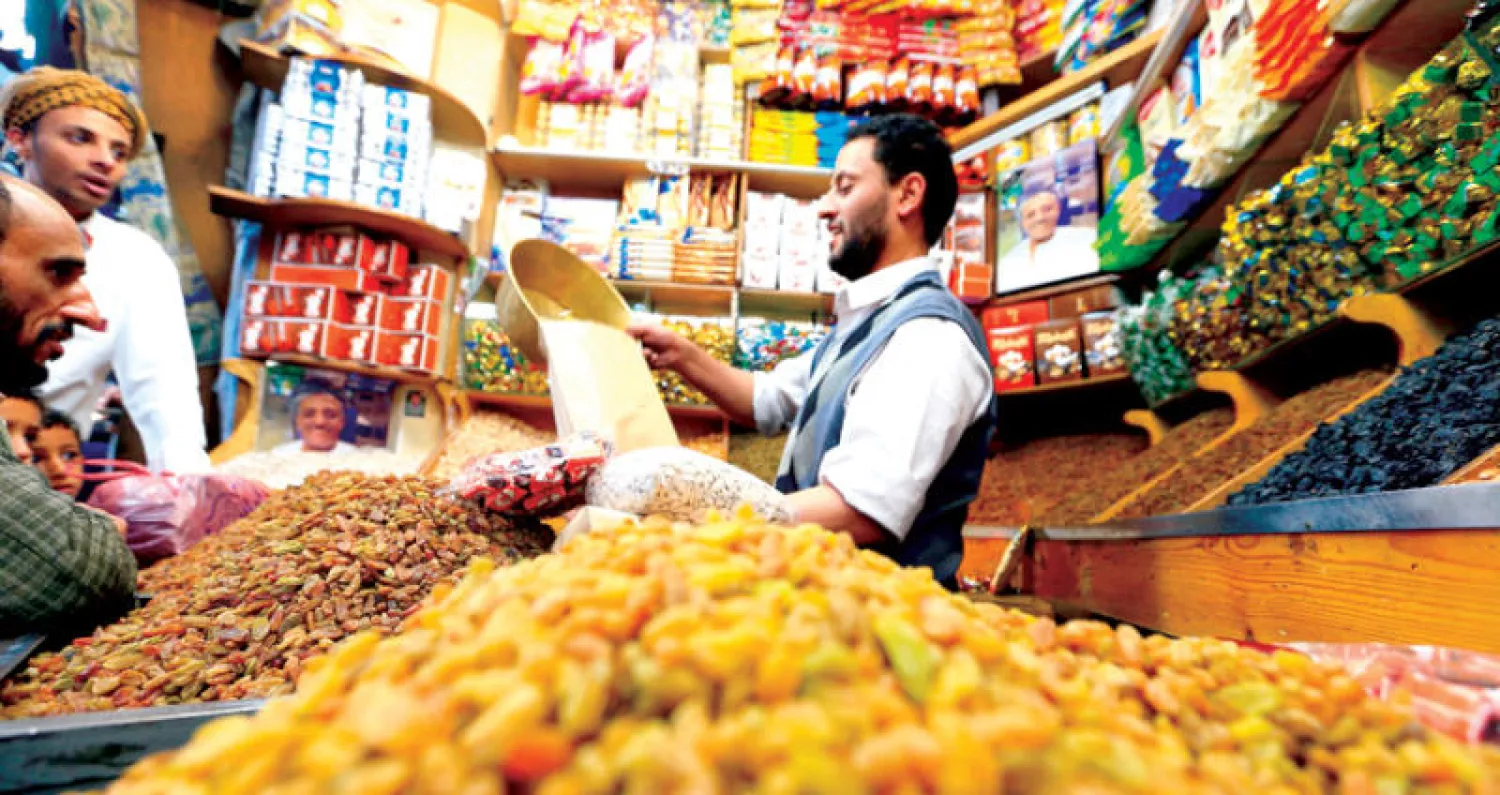 بائع يجهّز طلباً لزبائنه بمتجر في صنعاء (أ.ف.ب)