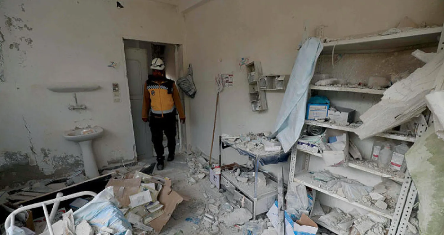 عنصر من «الخوذ البيضاء» يتفحص الدمار الذي لحق بمركز طبي بعد غارة على الهبيط جنوب إدلب (أ.ف.ب)