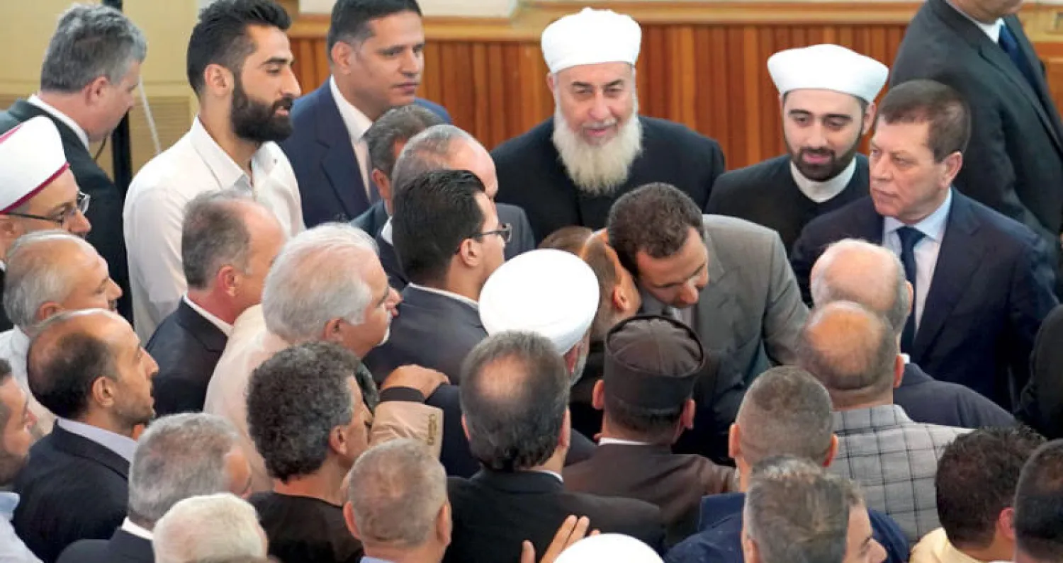 الأسد مع مواطنين بعد صلاة العيد في دمشق أمس (إ.ب.أ)