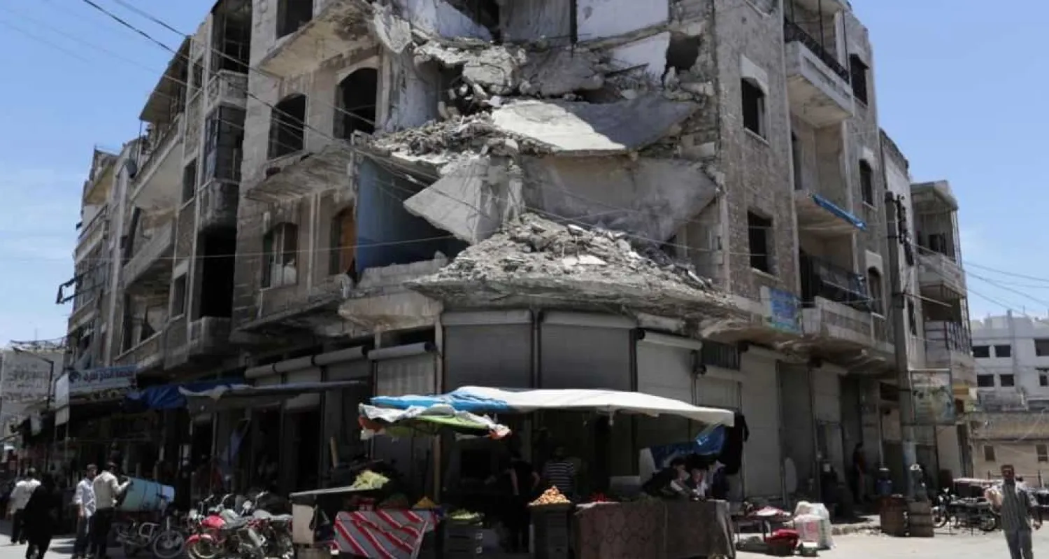 FILE - People walk past a damaged building in the city of Idlib, Syria, May 25, 2019 (Reuters)