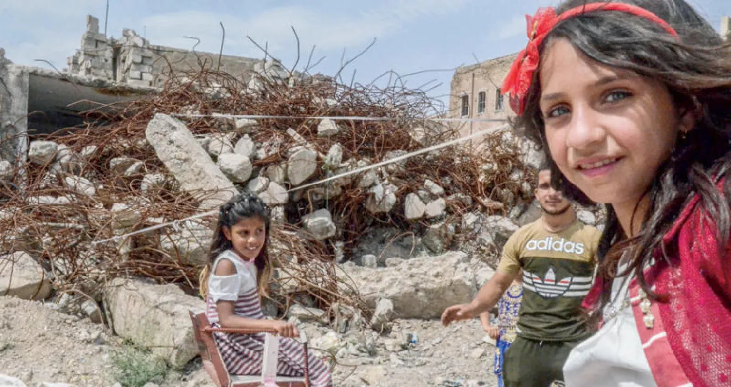 أطفال عراقيون يلهون بالأراجيح احتفالاً بعيد الفطر في شمال مدينة الموصل (أ.ف.ب)