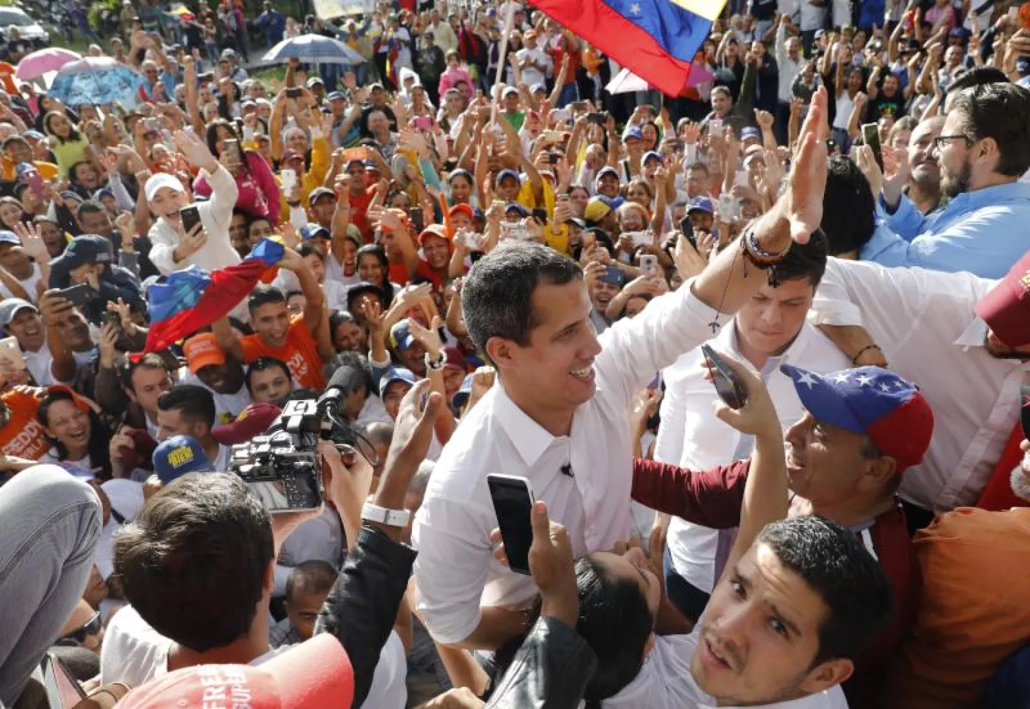 خوان غوايدو زعيم المعارضة الفنزويلية الذي أعلن نفسه رئيساً بالوكالة يحيي أنصاره خلال مسيرة بمدينة باريناس (أ.ب)