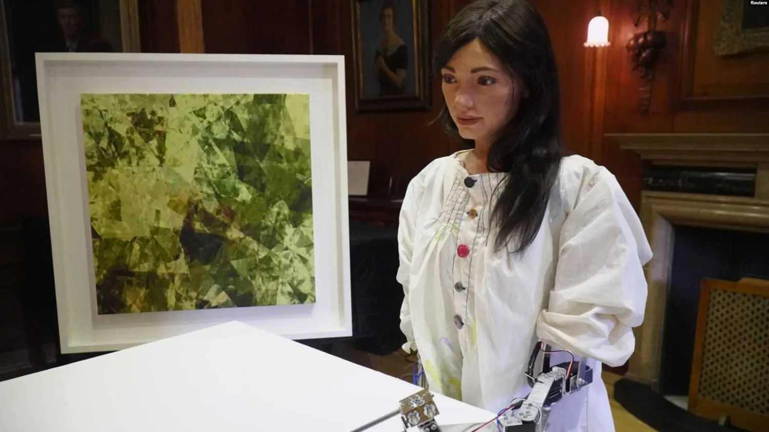 Robot artist 'Ai-Da' sketches using a pencil attached to her robotic arm, while standing next to a painting based on her computer vision data when run through algorithms developed by computer scientists in Oxford, Britain, June 4, 2019. Reuters