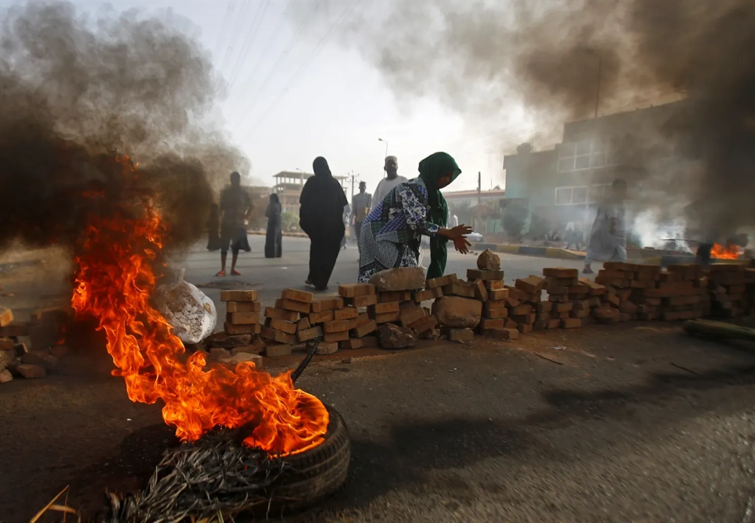 Sudanese protesters close Street 60 with burning tires and pavers as military forces tried to disperse a sit-in outside Khartoum's army headquarters. (AFP)