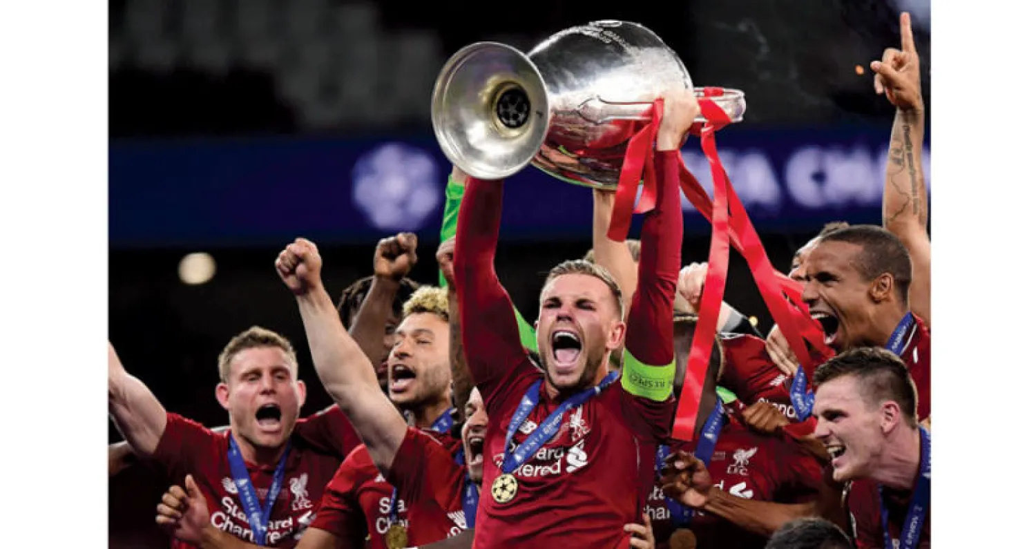 هندرسون على منصة التتويج يحتفل بكأس أبطال أوروبا في لحظة وعد بها والده منذ أن كان طفلاً (أ.ف.ب)