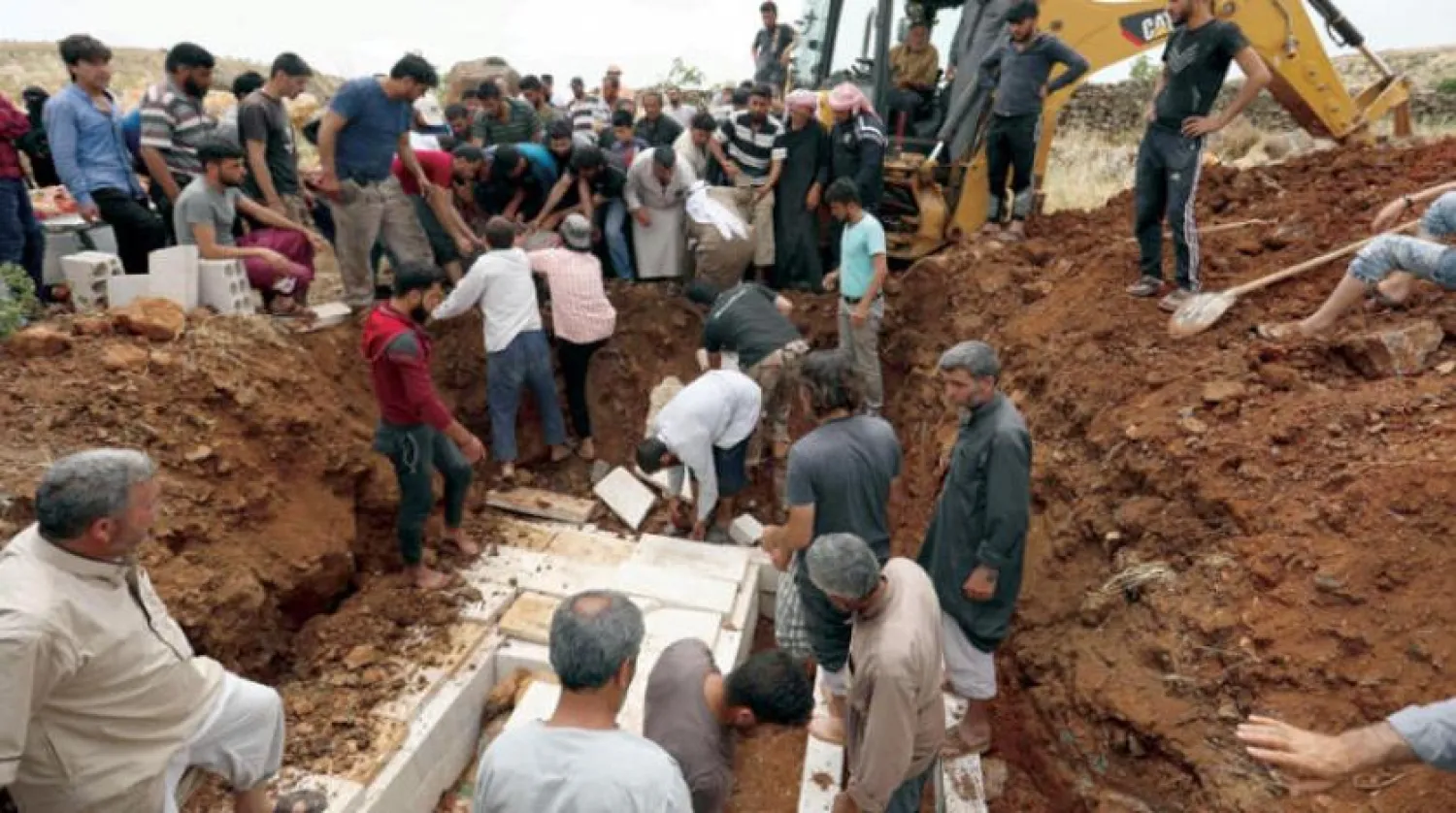 İdlib'deki Kefr Uveyt köyü sakinleri, düzenlenen hava saldırılarının kurbanlarını defnetti. (AFP)