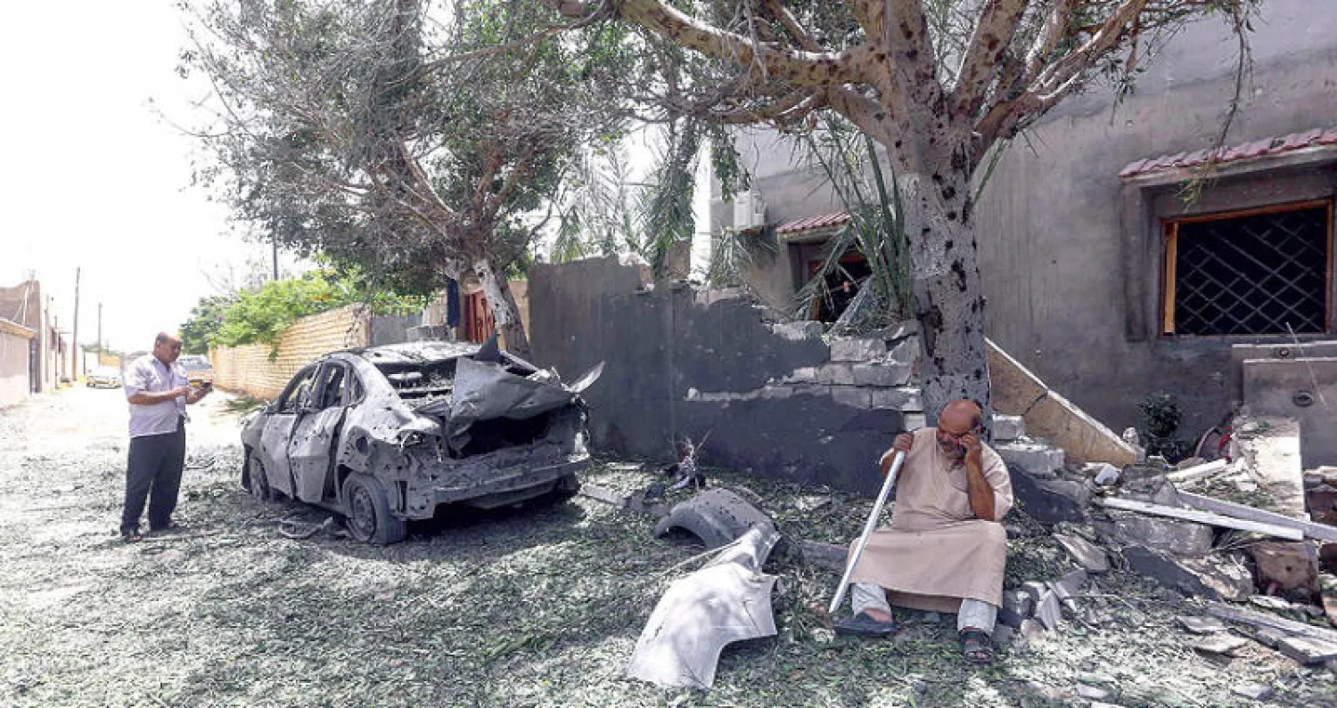 ليبي يعاين سيارته التي تعرضت للقصف في منطقة تاجوراء شرق العاصمة طرابلس (أ.ف.ب)