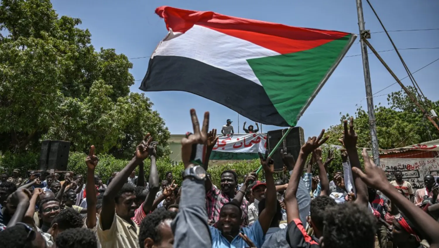 Sudanese protesters shout slogans and wave national flags during a protest outside the army headquarters in the capital Khartoum on April 22, 2019. (AFP)