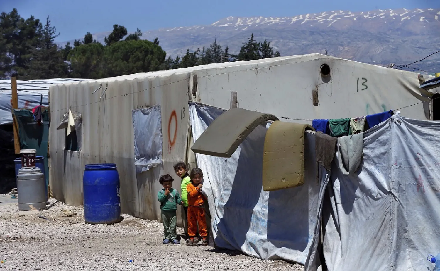 Syrian refugee children stand next to their family tents at a Syrian refugee camp in the town of Bar Elias, in Lebanon's Bekaa Valley, April 23, 2018. (AP)