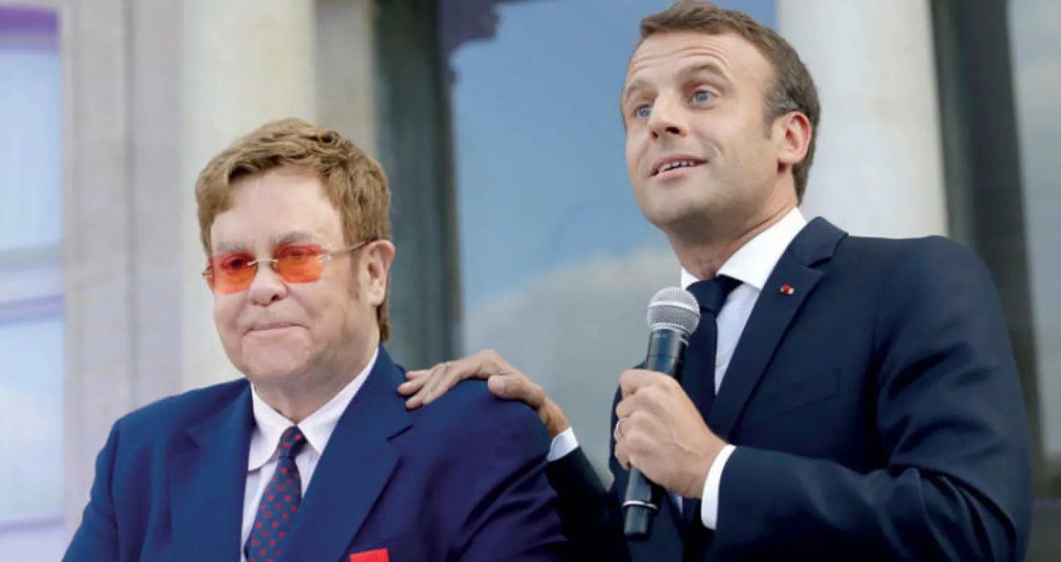 الرئيس  ماكرون والمغني الإنجليزي التون جونز في حديقة قصر الإليزيه في باريس أول من أمس (أ.ب)