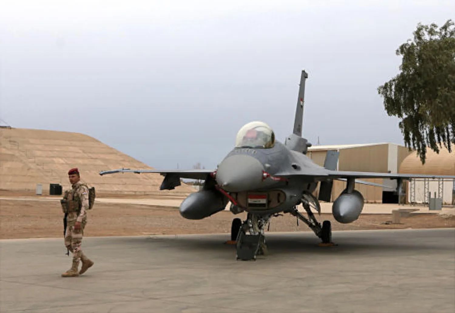 FILE - in this Tuesday, Feb. 13, 2018 file photo, an Iraqi army soldier stand guard near a US- made Iraqi Air Force F-16 fighter jet at the Balad Air Base, Iraq.  (AP Photo/Khalid Mohammed, File)
