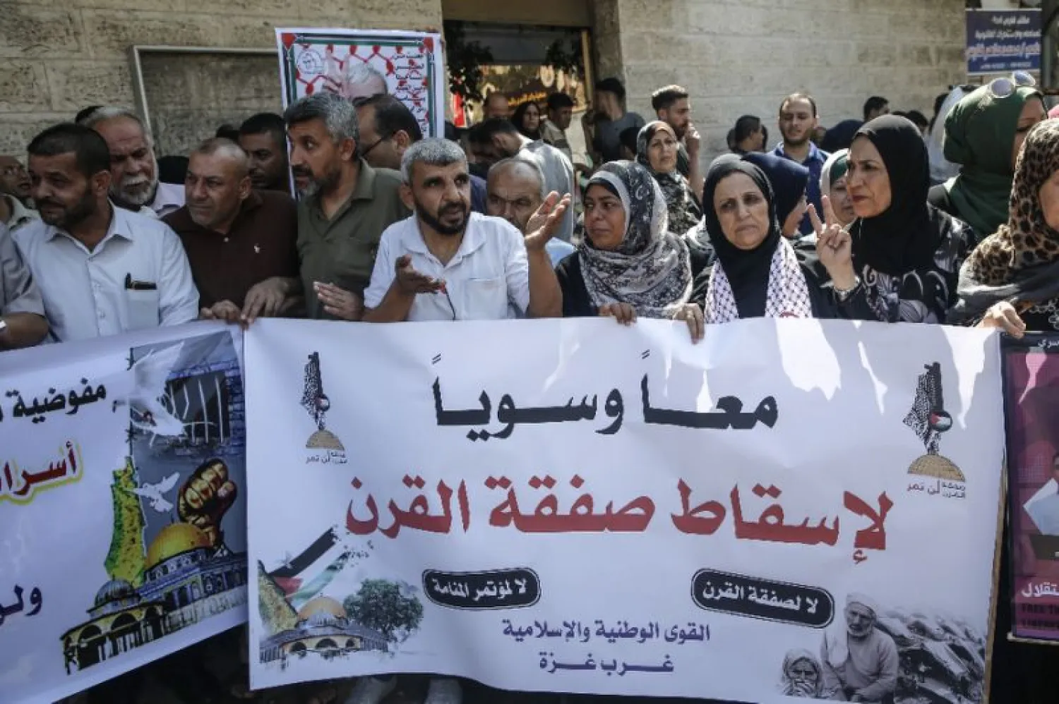 Palestinians in Gaza City hold banners denouncing the US-led Peace to Prosperity conference in Bahrain | AFP
