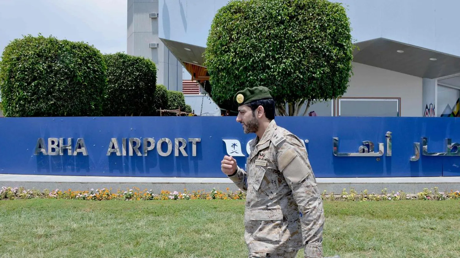 A Saudi serviceman walks by a sign outside Abha airport. (AFP)