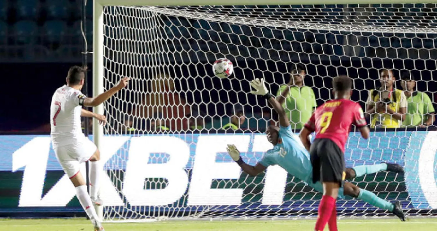 المسكاني قائد منتخب تونس يسجل من ركلة الجزاء في مرمى أنغولا (رويترز)