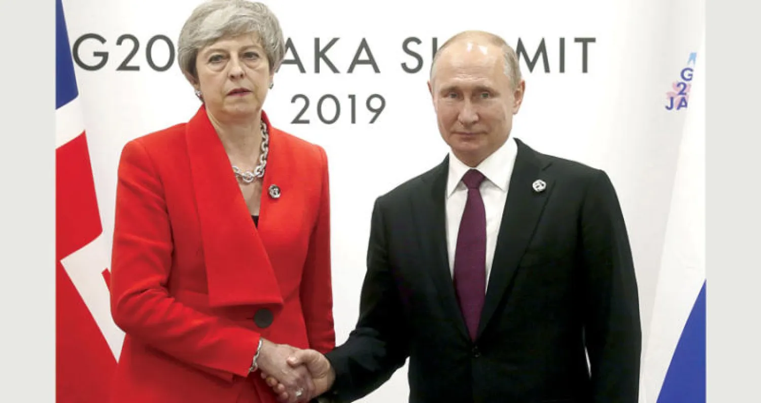 الرئيس بوتين ورئيسة الوزراء البريطانية تيريزا ماي خلال لقاء على هامش قمة العشرين في أوساكا أمس (إ.ب.أ)