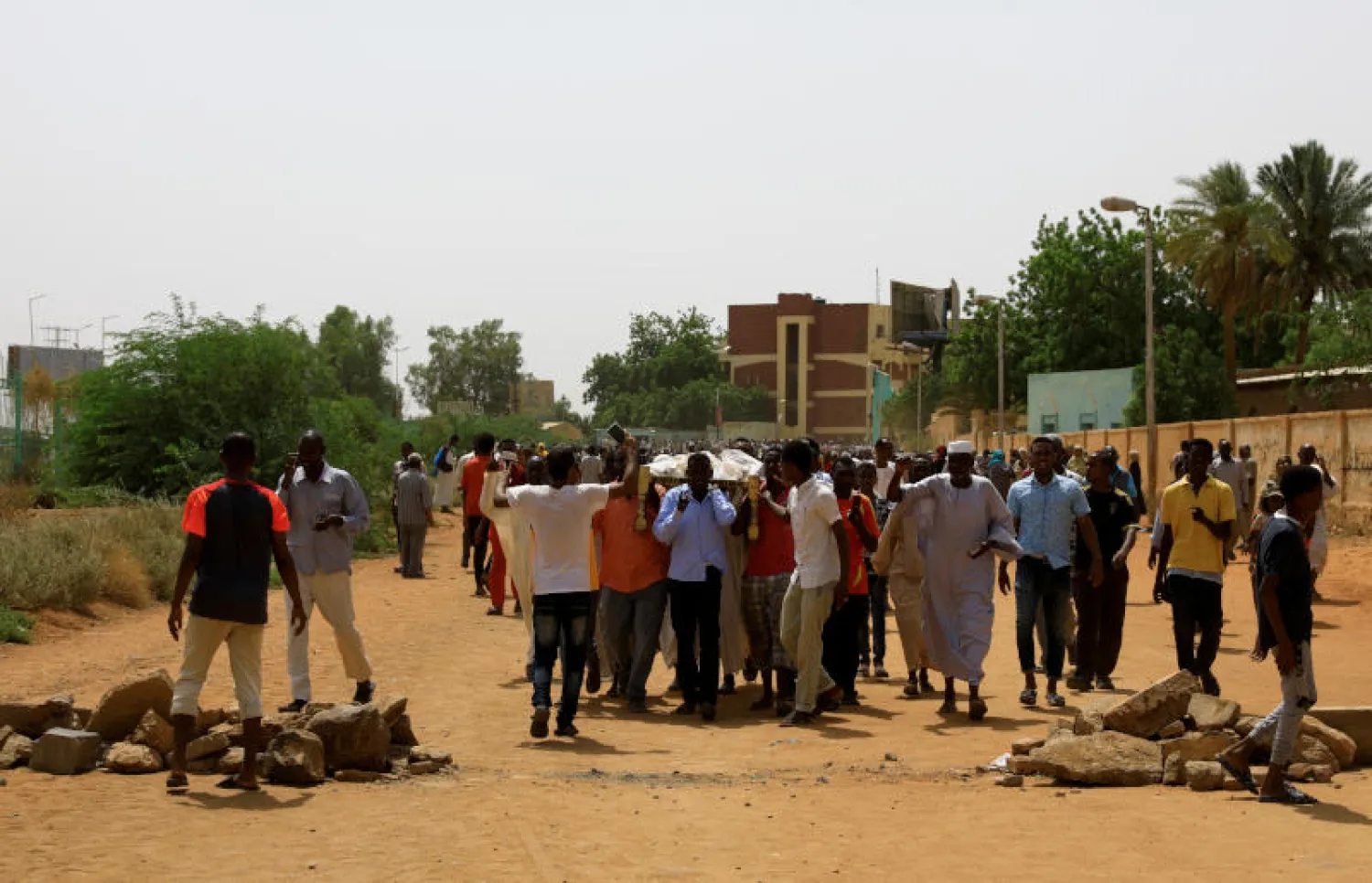 متظاهرون سودانيون يحملون جثث 3 من ضحايا الاحتجاجات (رويترز)