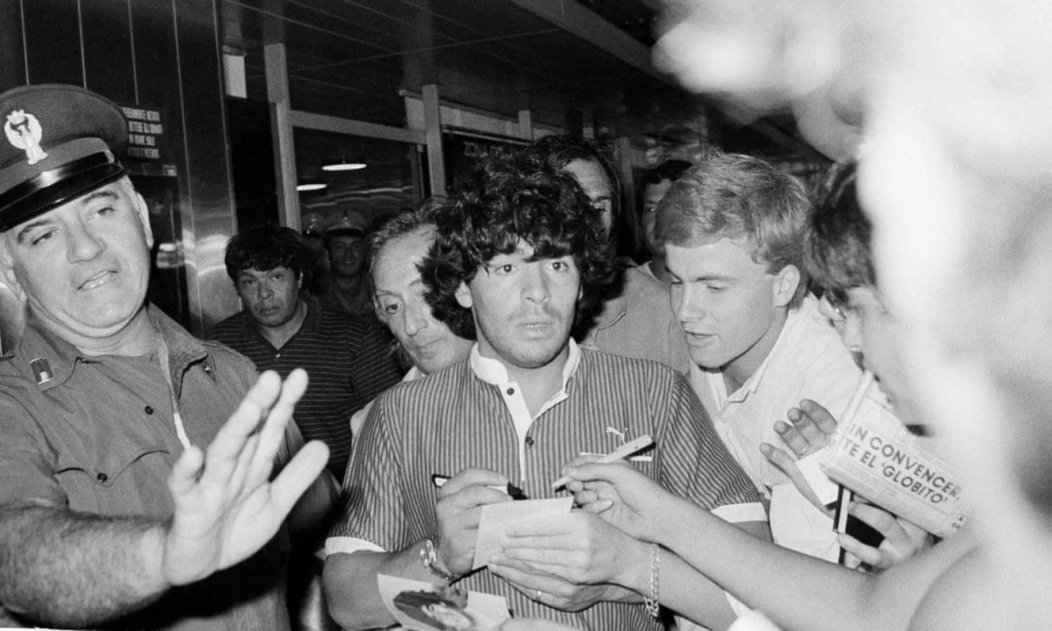 Diego Maradona thronged by fans after landing at Rome airport in July 1984, the month he signed for Napoli. Photograph: Bruno Mosconi/AP
