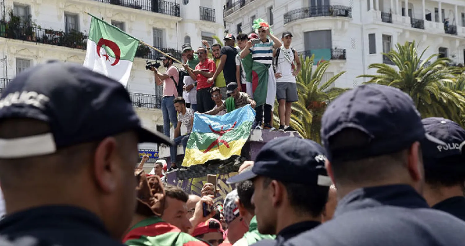 رجال أمن في مواجهة محتجين يرفع بعضهم علم الأمازيغ في العاصمة الجزائرية الشهر الماضي (أ.ف.ب)