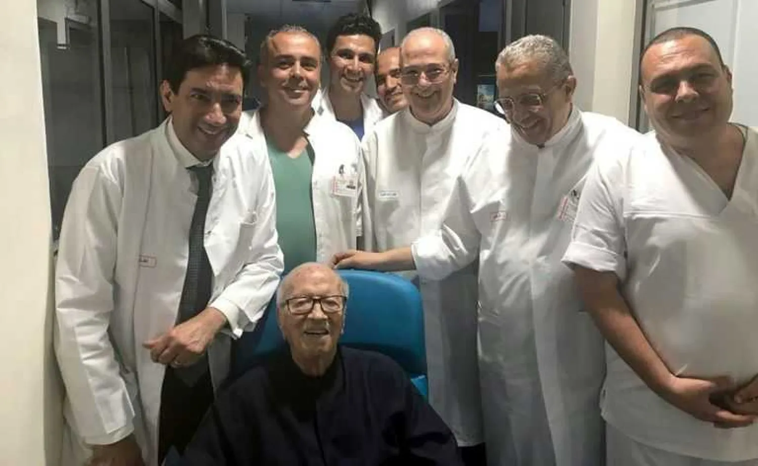 Tunisian President Beji Caid Essebsi smiles as he leaves hospital surrounded by his doctors. AFP Photo
