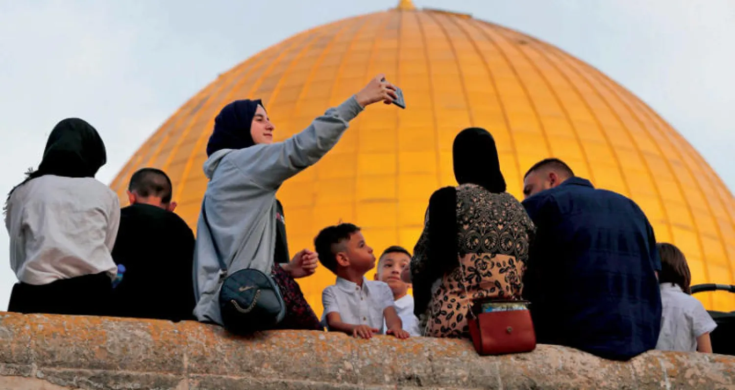 فلسطينيون يحتفلون بعيد الفطر الشهر الماضي في المسجد الأقصى (أ.ف.ب)