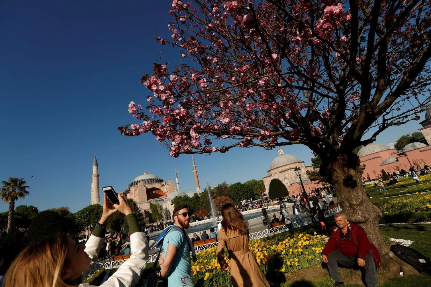 A foreign tourist, with the Byzantine-era monument of Hagia Sophia in the background, takes pictures at Sultanahmet square in Istanbul, Turkey April 21, 2018. (Reuters)