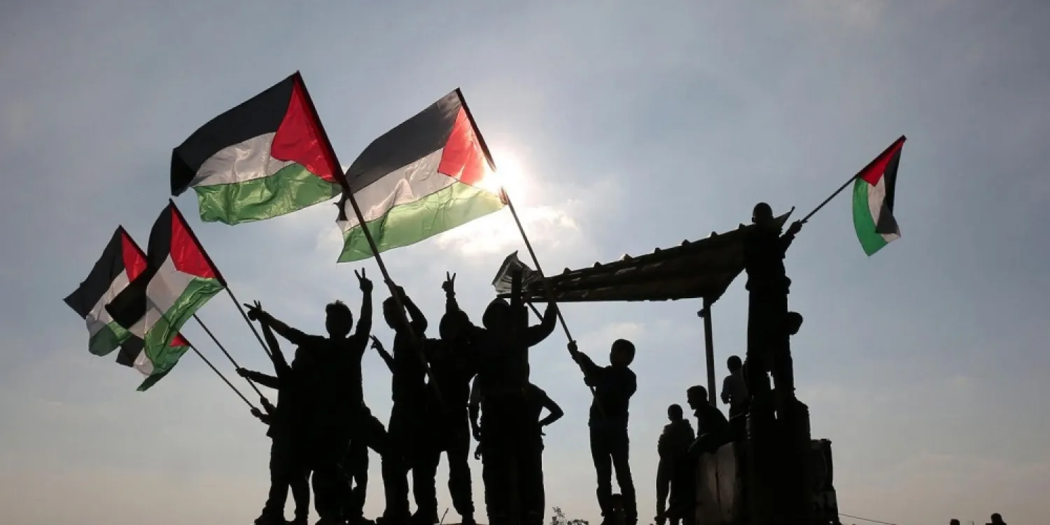 Palestinian protesters wave their national flag near the Israel-Gaza border. (Reuters file photo)