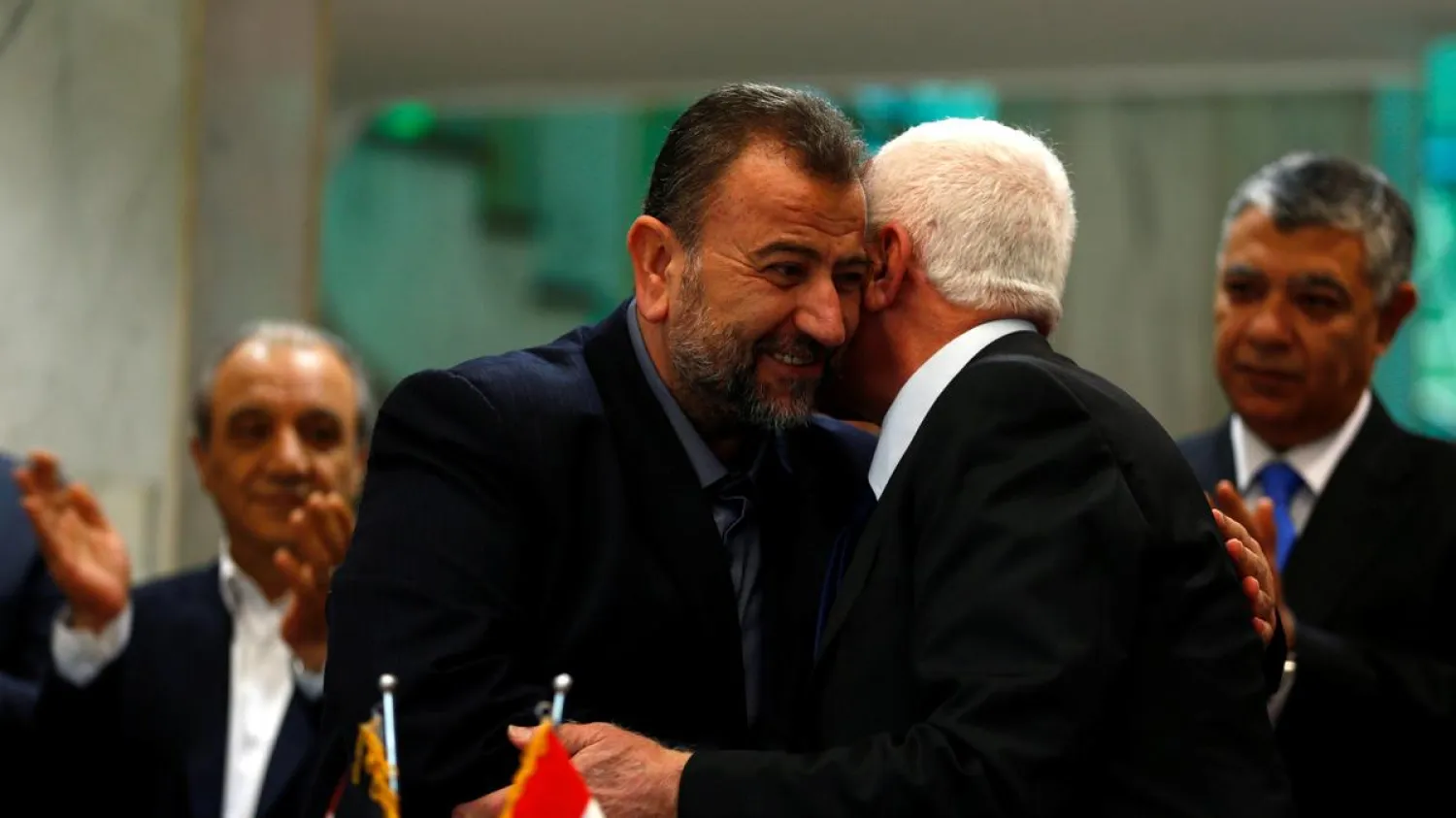 Hamas delegation head Saleh Arouri hugs Fatah leader Azzam Ahmad as they sign a reconciliation deal in Cairo on October 12, 2017. Amr Abdallah Dalsh / Reuters
