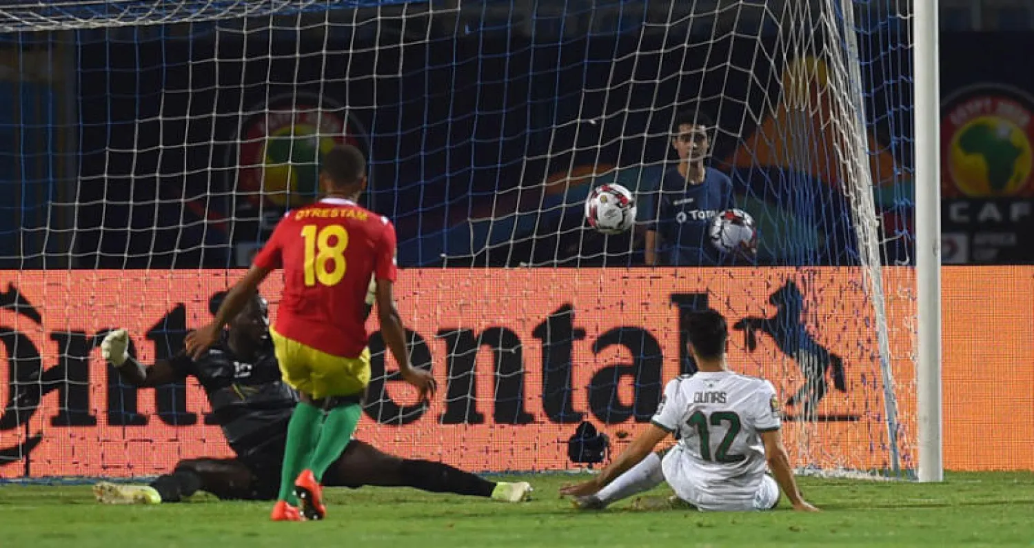 آدم أوناس نجم الجزائر (يمين) يسجل ثالث أهداف منتخب بلاده في مرمى غينيا (أ.ف.ب)