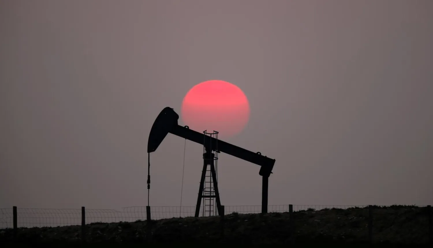 The sun sets behind an oil pump outside Saint-Fiacre, near Paris, France March 28, 2019. REUTERS/Christian Hartmann