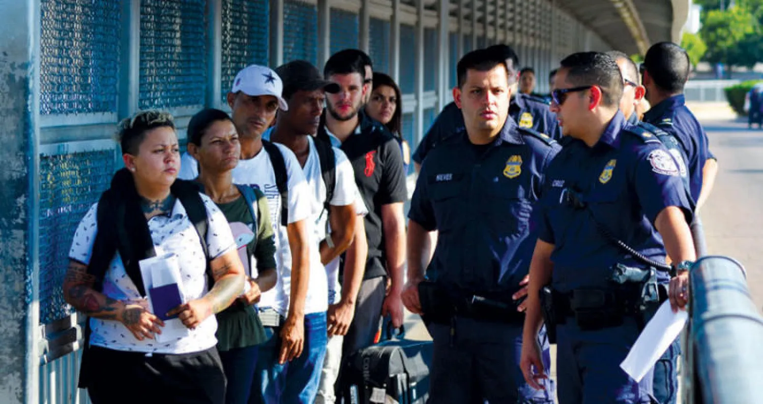 وكلاء من إدارة الهجرة وحراس الحدود خلال تسليم مجموعة من المهاجرين للمكسيك (أ.ب)