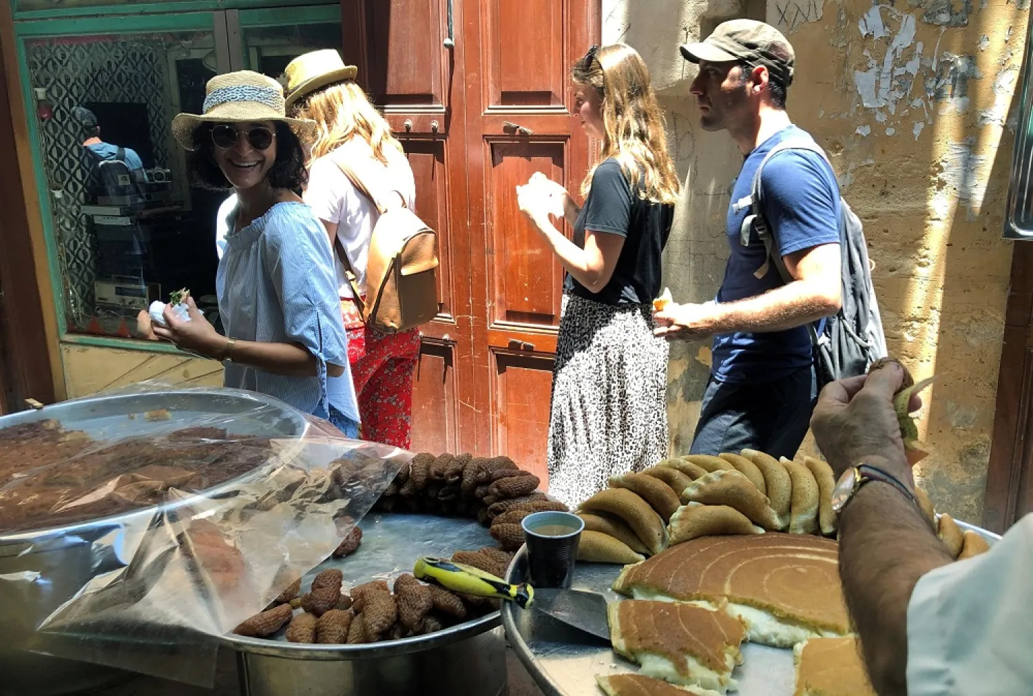 Tourists walk past a shop selling traditional sweets in the southern port city of Sidon, Lebanon July 9, 2019. (Reuters)