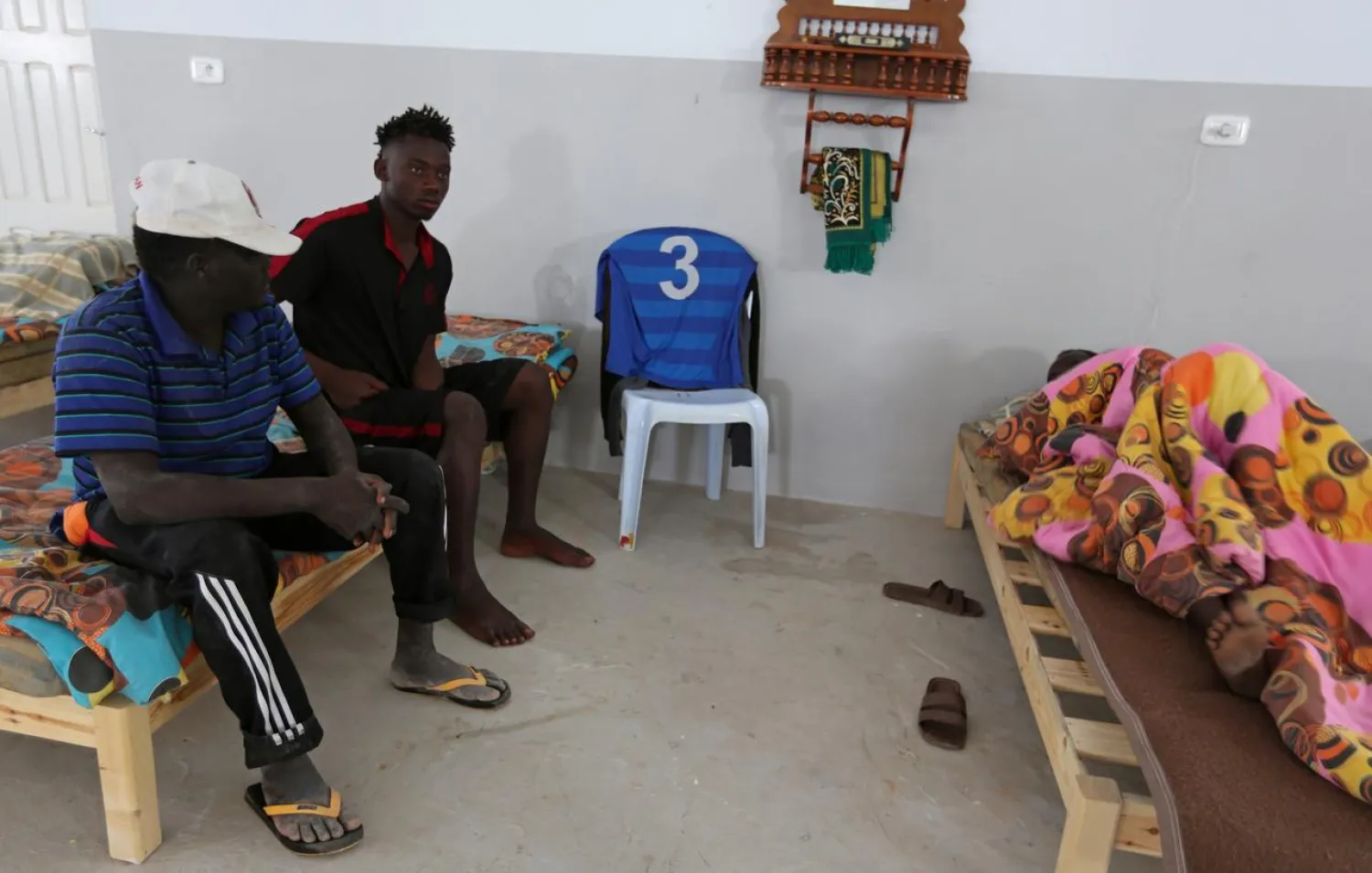 An African migrant (C), who was rescued after the boat he was travelling capsized in the Mediterranean Sea off the Tunisian Coast, sits inside a local Red Crescent chapter in Zarzis, Tunisia July 4, 2019. REUTERS/Stringer