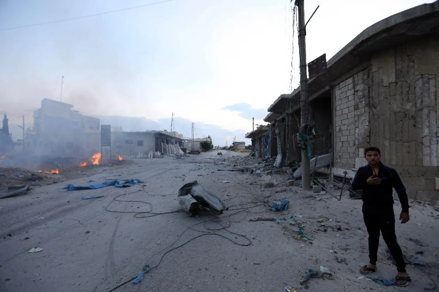 A man looks on at the site of a rocket attack by Syrian regime forces and their allies on the village of Kafr Nabl, south of Idlib. (AFP)