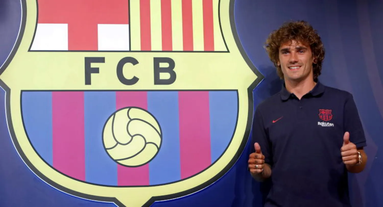 أنطوان غريزمان بجوار شعار برشلونة (إ.ب.أ)