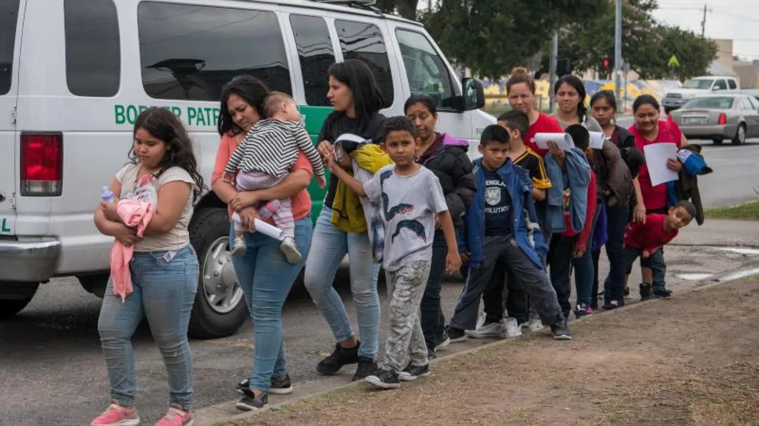 عائلات المهاجرين من أميركا الوسطى أمام مركز استراحة للجمعيات الخيرية في تكساس (أ.ف.ب)