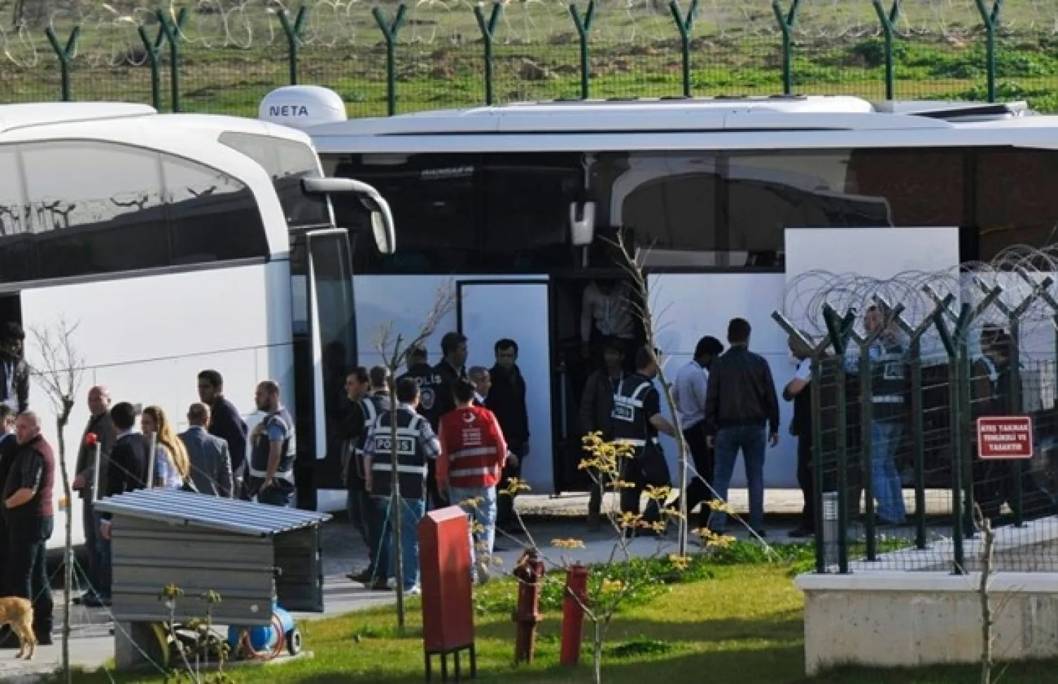 Turkish security members surround migrants after their arrival in Pehlivankoy, Kirklareli, Turkey, Monday, April 4, 2016. Migrants have been sent to a deportation center in Pehlivankoy as part of a controversial deal between the EU and Turkey, according to a state-run news agency. (AP Photo/Ergin Yildiz)

