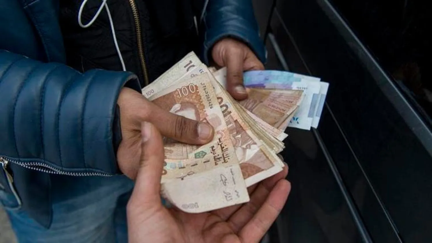 Man handling Moroccan currency (AFP)
