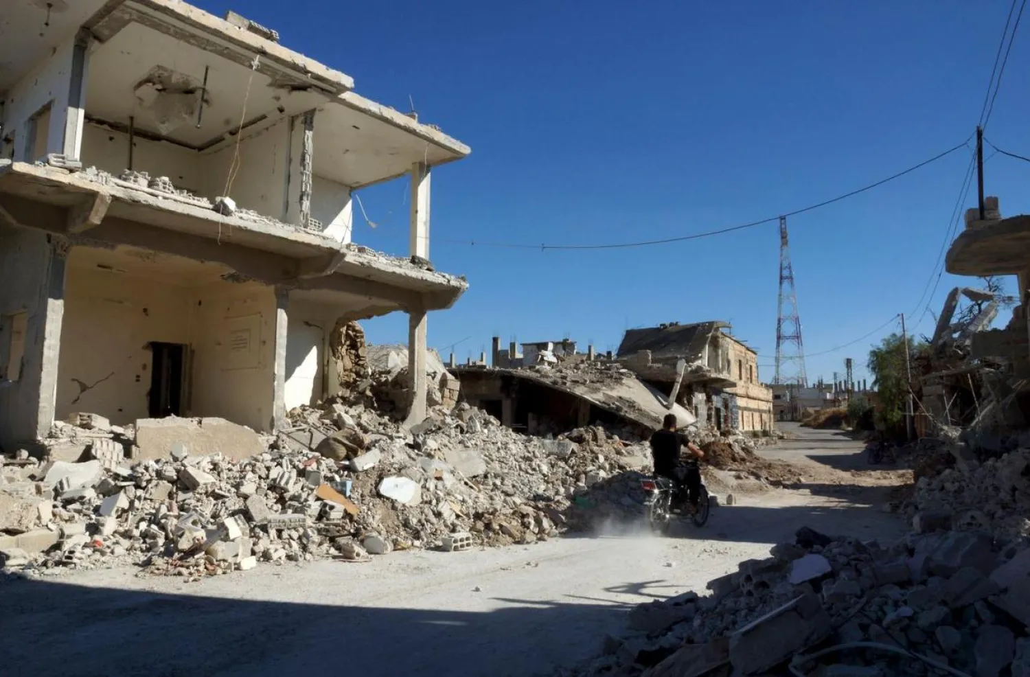 A man drives a motorcycle through a damaged neighbourhood in Daraa Al-Balad, Syria June 23, 2015. (File photo: Reuters)
