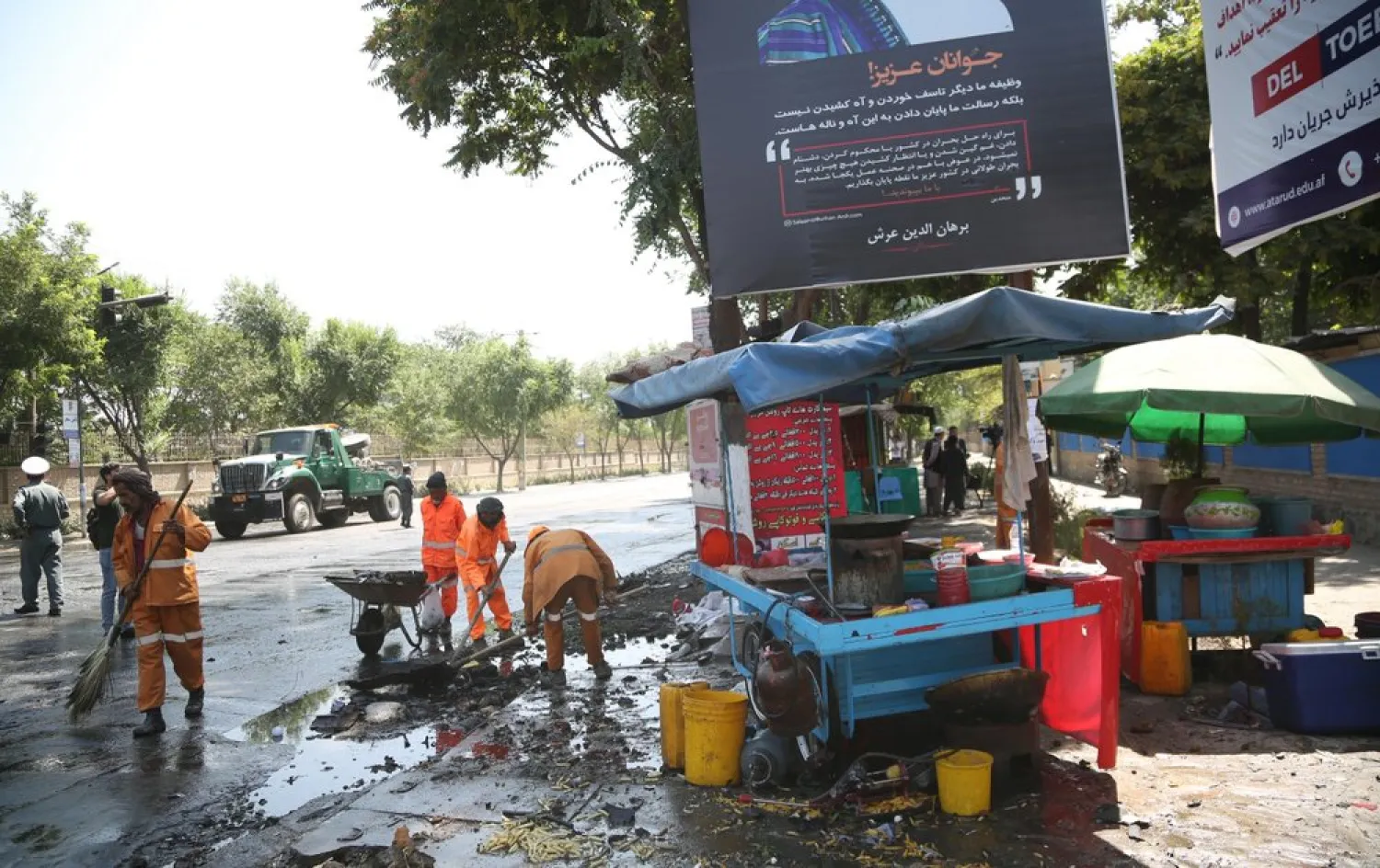 Workers clean the site of an explosion in Kabul, Afghanistan, Friday, July 19, 2019. A powerful bomb exploded outside the gates of Kabul University in the Afghan capital on Friday, according to police and health officials. (AP Photo)
