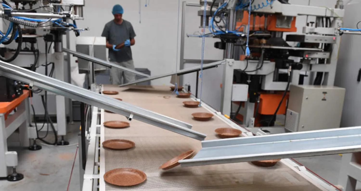 عامل في مصنع ينتج أطباق الوجبات من القمح الصالح للأكل في بولندا للتغلب على إعادة التدوير (أ.ف.ب)