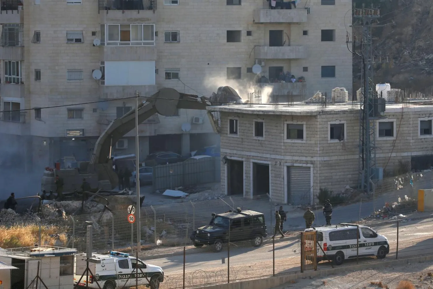An Israeli machinery demolishes a Palestinian building in the village of Sur Baher which sits on either side of the Israeli barrier in East Jerusalem and the Israeli-occupied West Bank July 22, 2019. REUTERS/Mussa Qawasma
