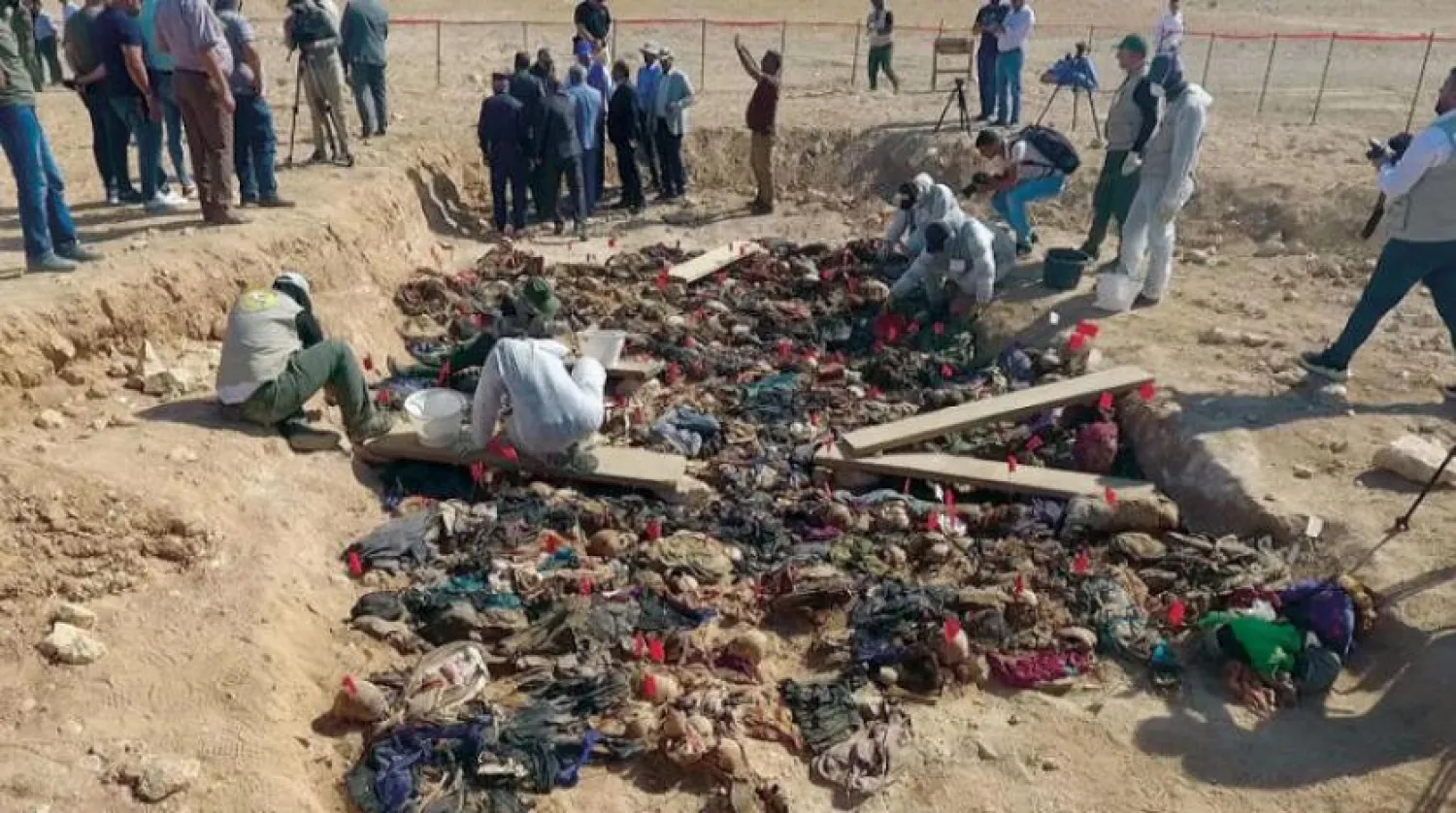 This aerial view taken by a drone on July 23, 2019 shows the site of a mass grave holding the remains of dozens of victims, including children, likely killed during Saddam Hussein's campaign against the country's Kurds, exhumed by the Baghdad-based Medico-Legal Directorate, in Tal al-Sheikhiya in the southern province of Mutahanna, about 300 kilometres south of the capital. Hussein AL-KHAZALI / AFP