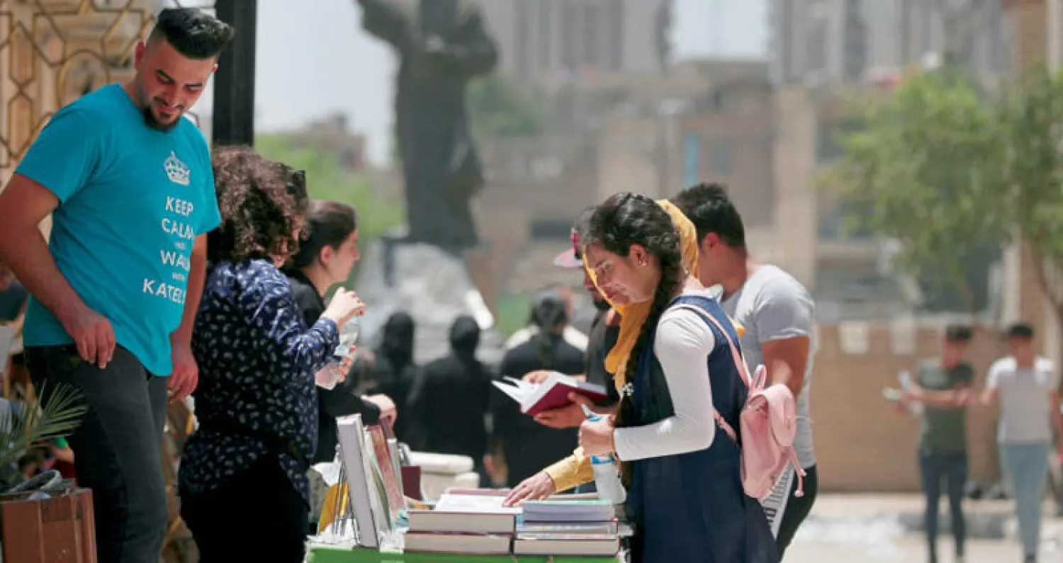 عراقيون يعاينون كتبا في شارع المتنبي ببغداد أمس (أ.ب)